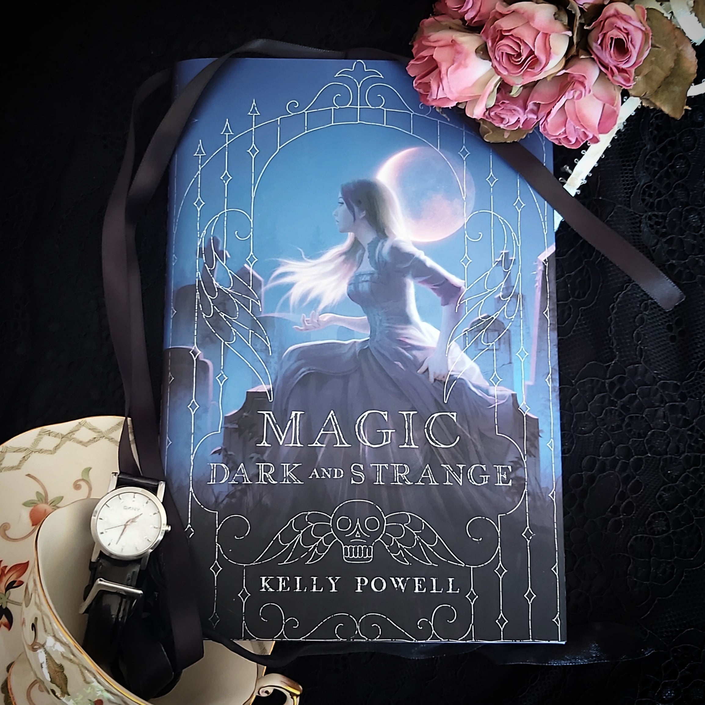 The book, Magic Dark and Strange by Kelly Powell, in a flatlay